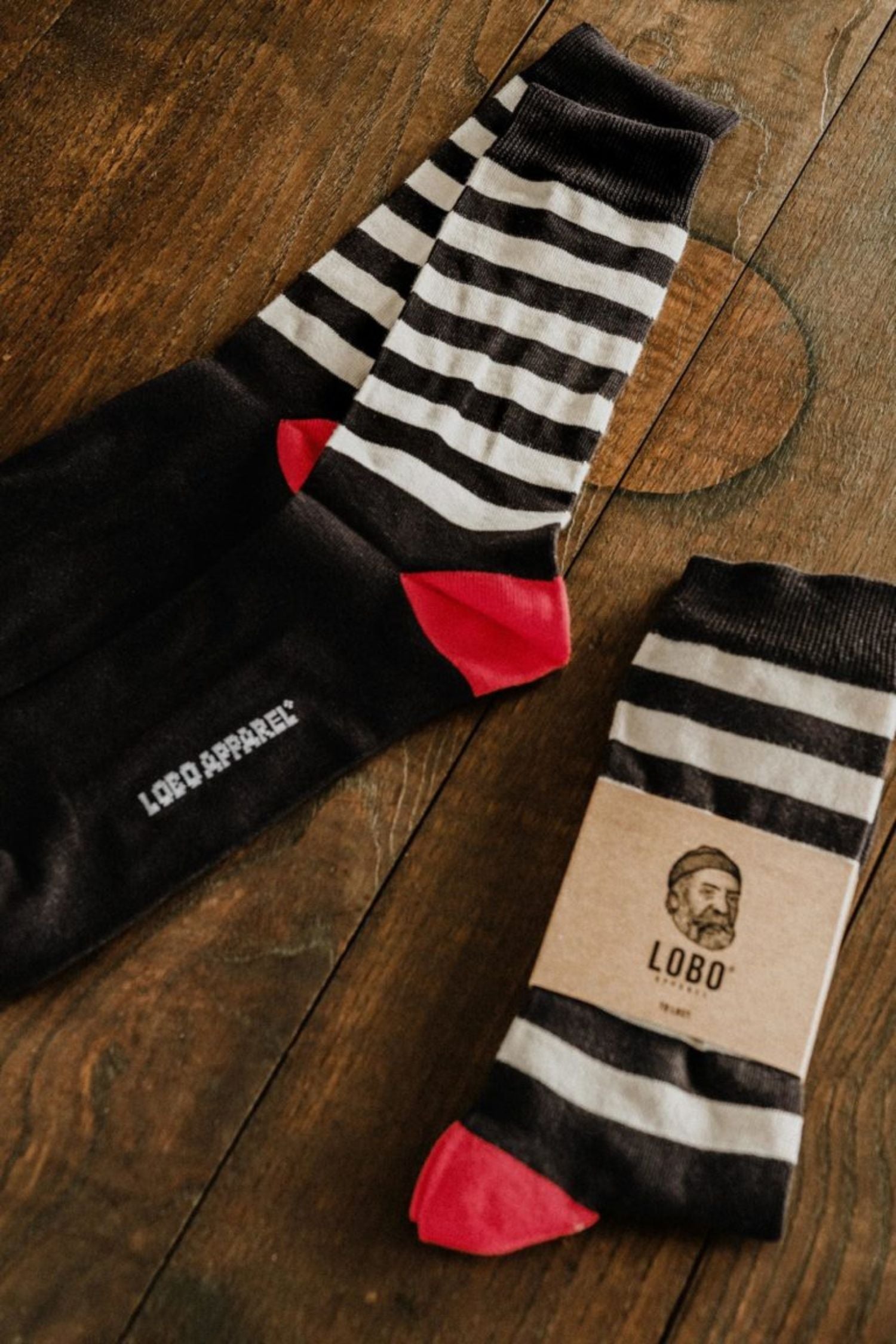 Set of Lobo Black Stripes cotton socks shown both unpacked and packaged, displaying the minimalist striped design.