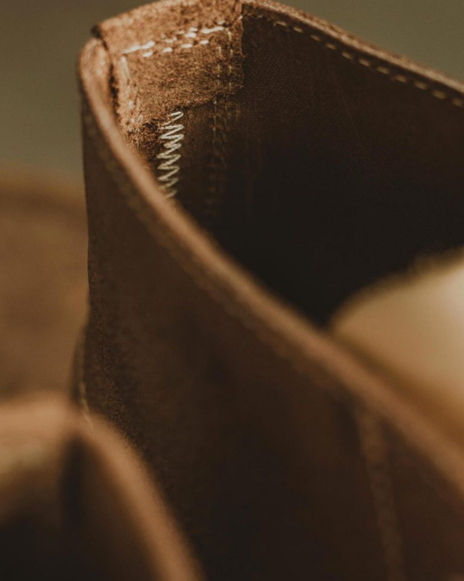 Close-up of zigzag stitching on the heel of Lobo Raw brown leather boots, showing durable construction.
