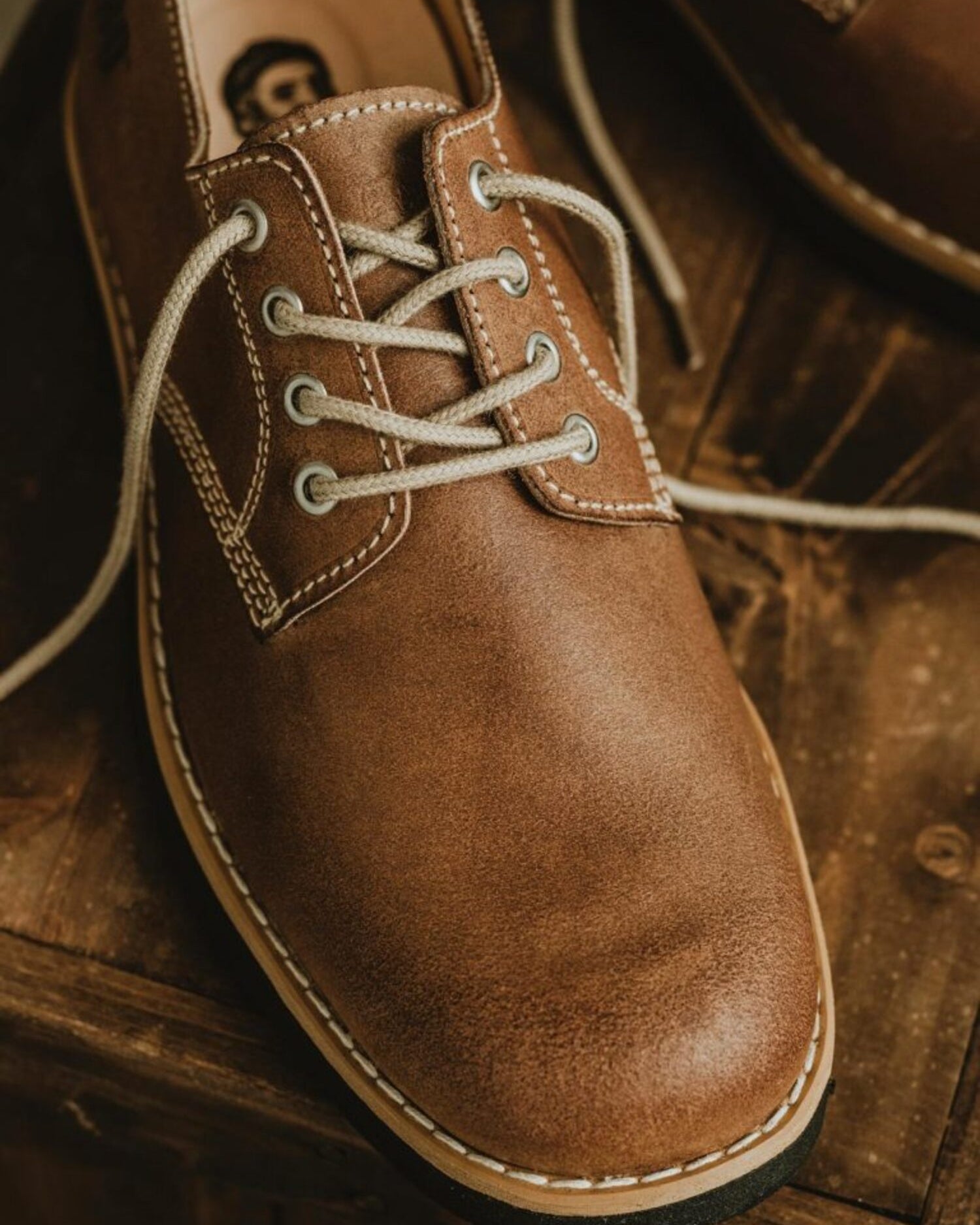 Front close-up of Lobo Raw leather shoe with cream cotton laces and reinforced stitching.