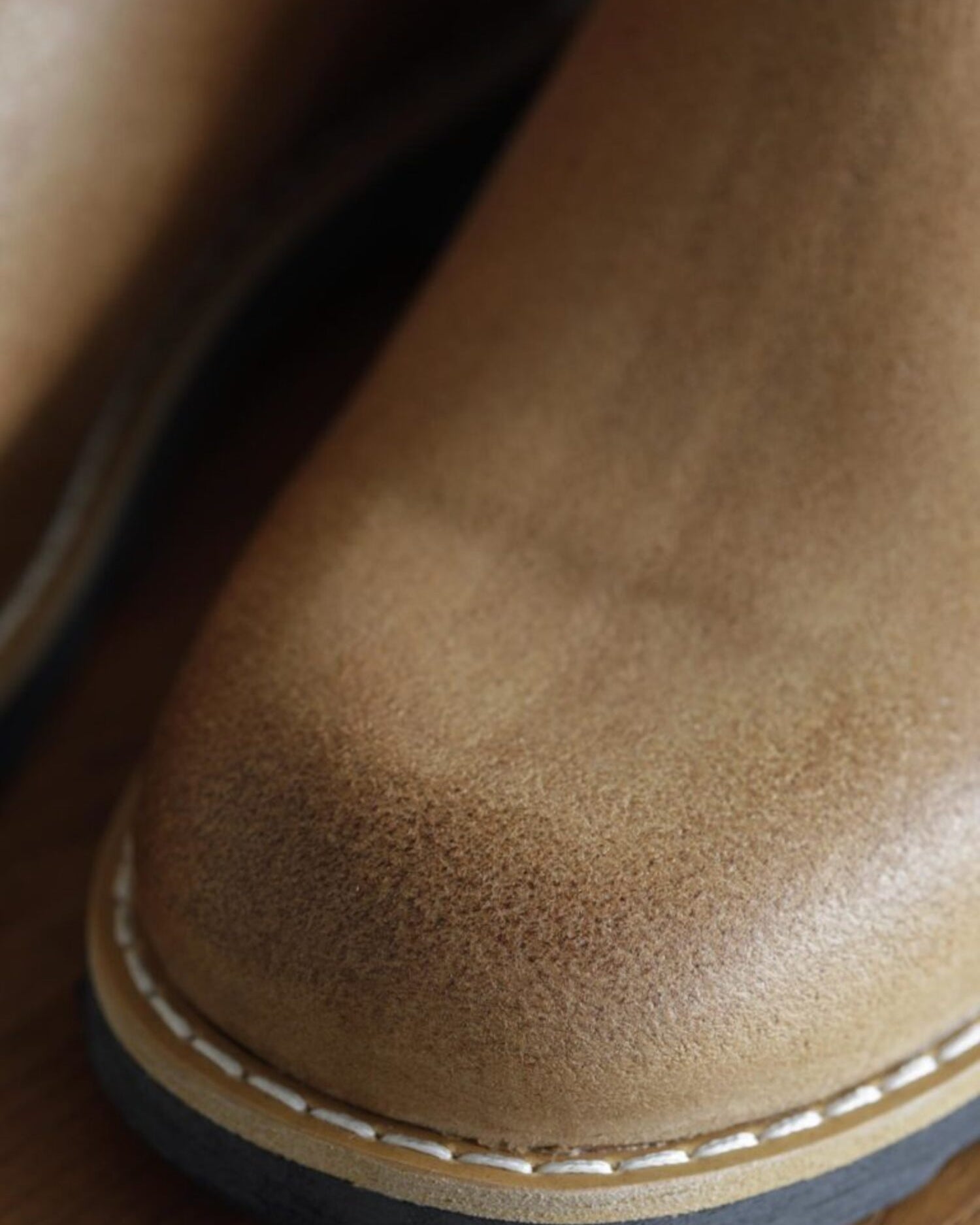 Macro shot of textured tan leather toe cap and welt stitching on Lobo Raw boots.