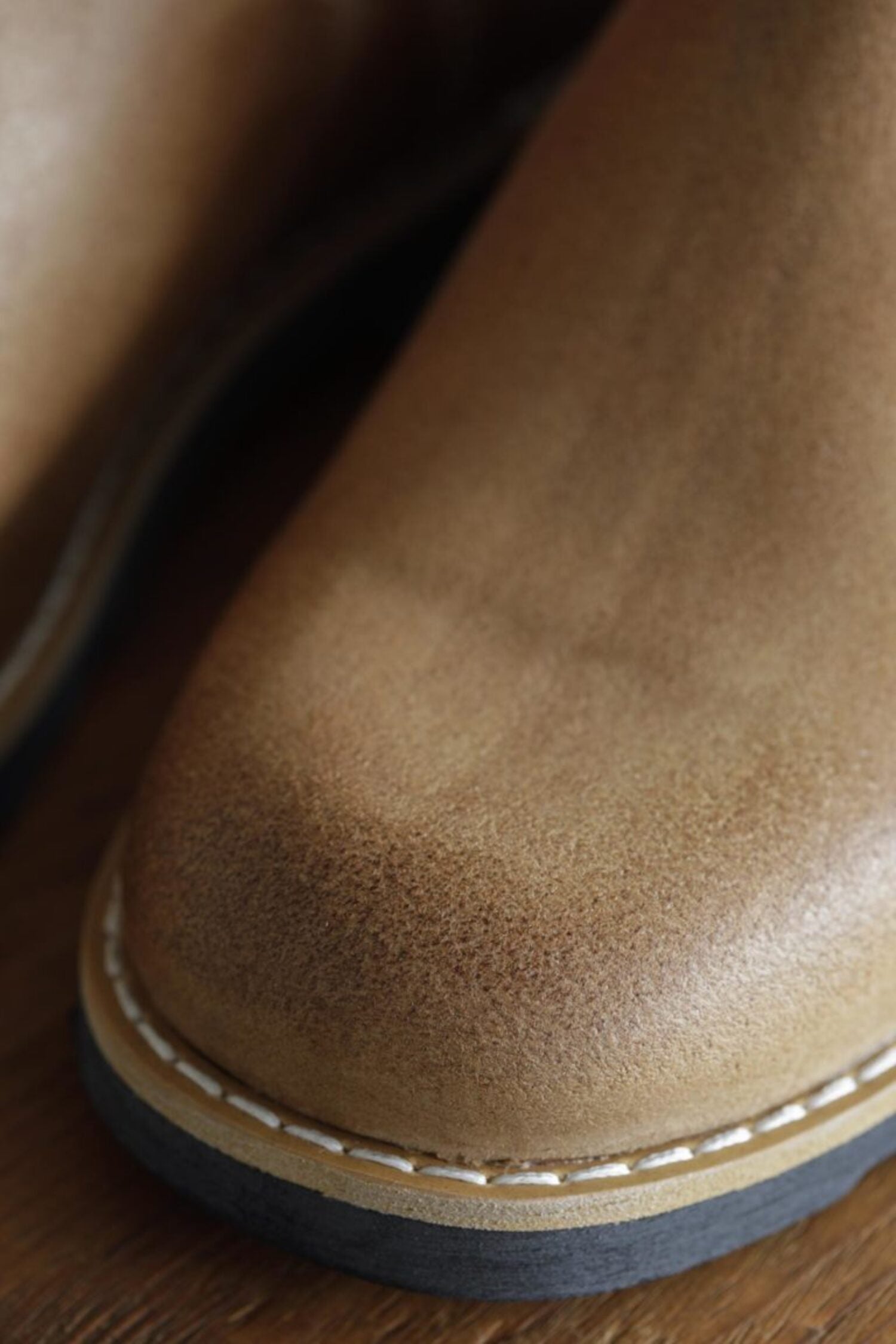 Macro shot of textured tan leather toe cap and welt stitching on Lobo Raw boots.