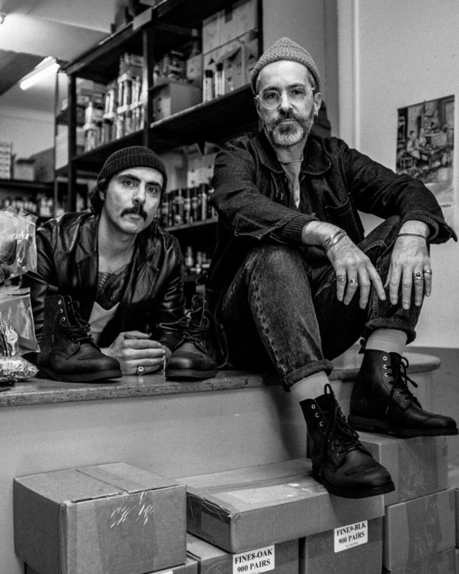 Black and white portrait of the Lobo x Casa Tigre collaborators in a workshop setting, surrounded by shoe boxes and the limited edition boots.