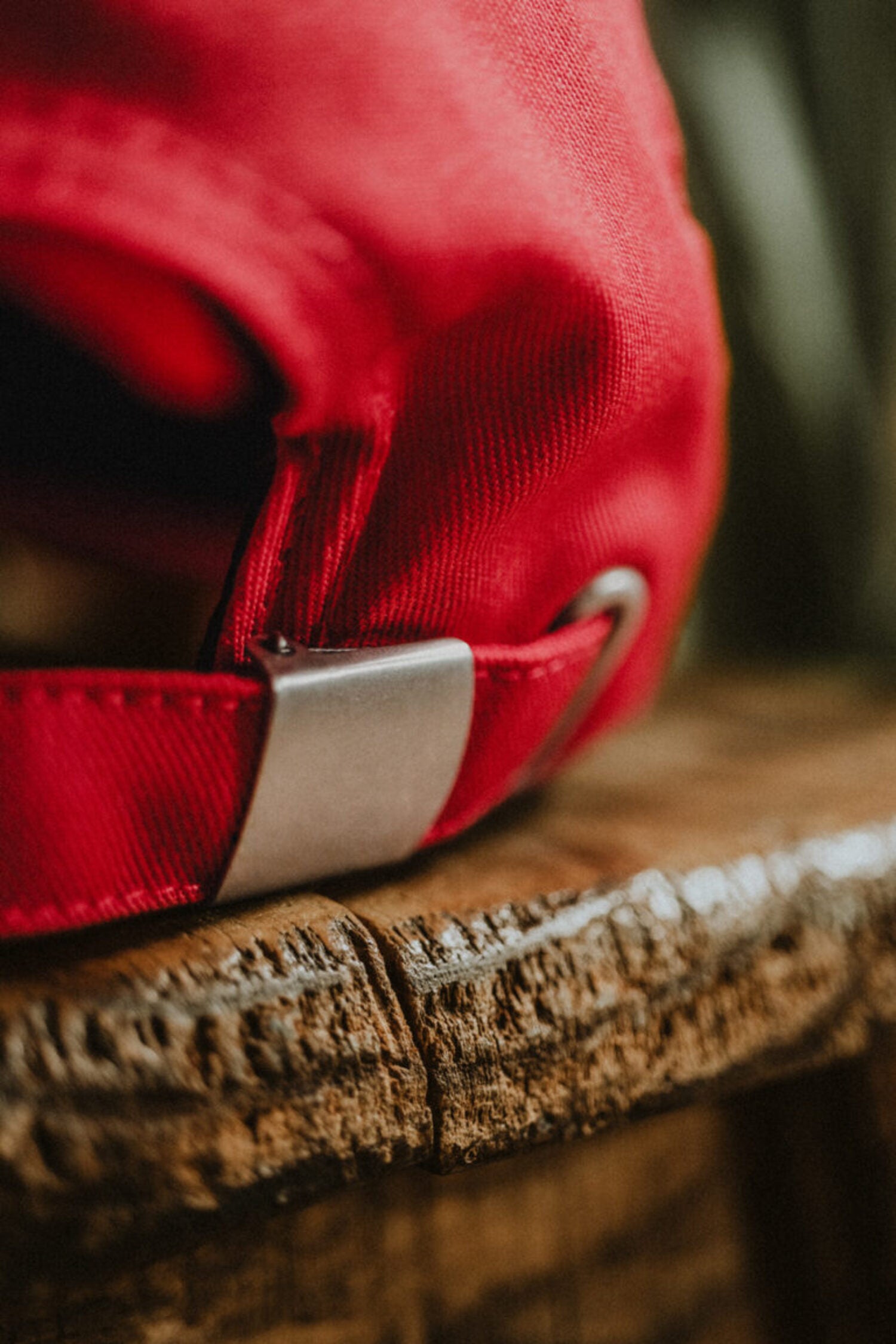 Detail of the adjustable metal strapback closure on a red LOBO cap, highlighting the durability of the hardware.