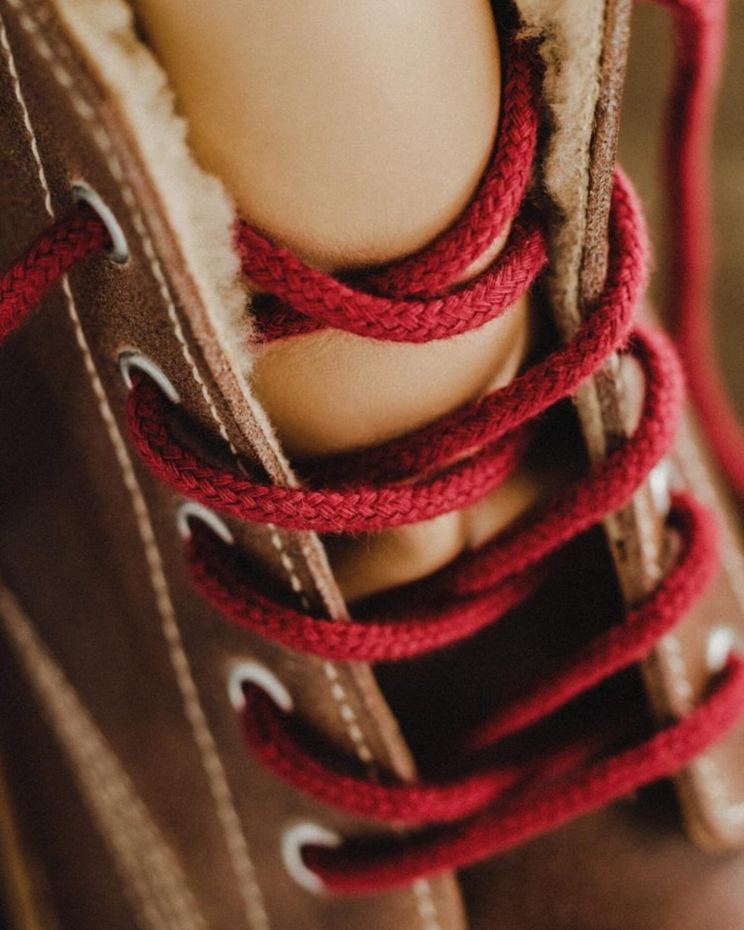 Close-up detail of the red laces and metallic eyelets on the Lobo leather boots.
