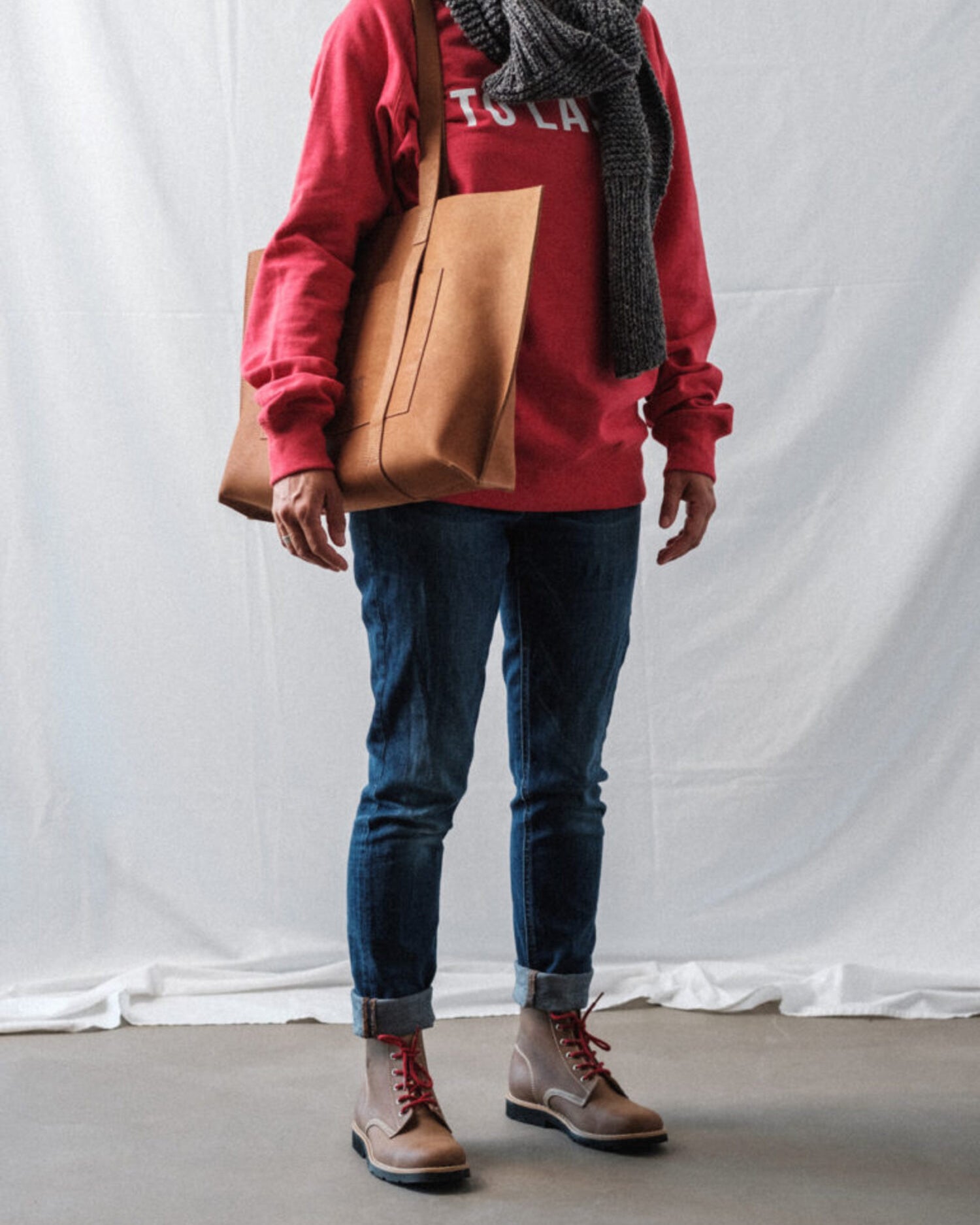 Female model wearing Lobo Warm Boots, denim jeans, red sweatshirt, and a grey wool scarf.