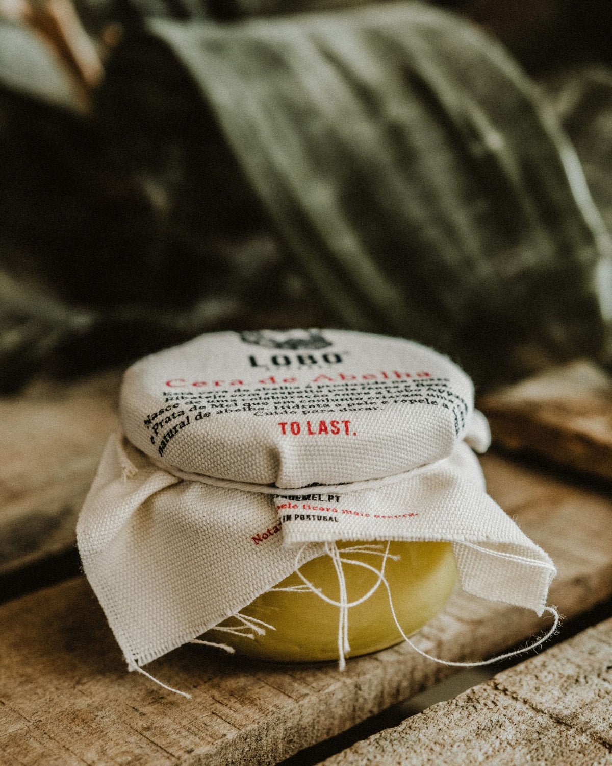 Beeswax boot conditioner jar with "To Last" label, emphasizing durability and leather footwear care.