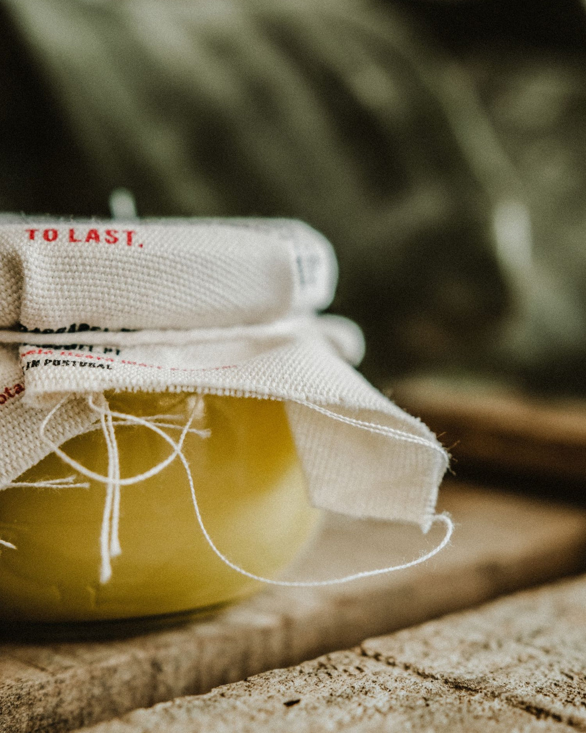 Close-up of the glass jar containing yellow beeswax and olive oil for deep leather conditioning and hydration.