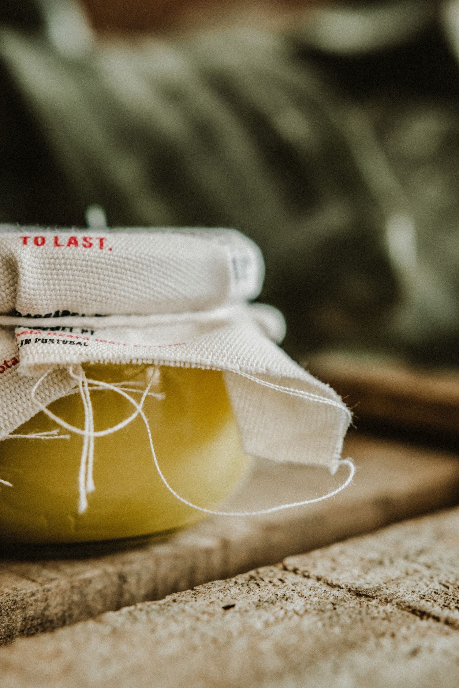 Close-up of the glass jar containing yellow beeswax and olive oil for deep leather conditioning and hydration.