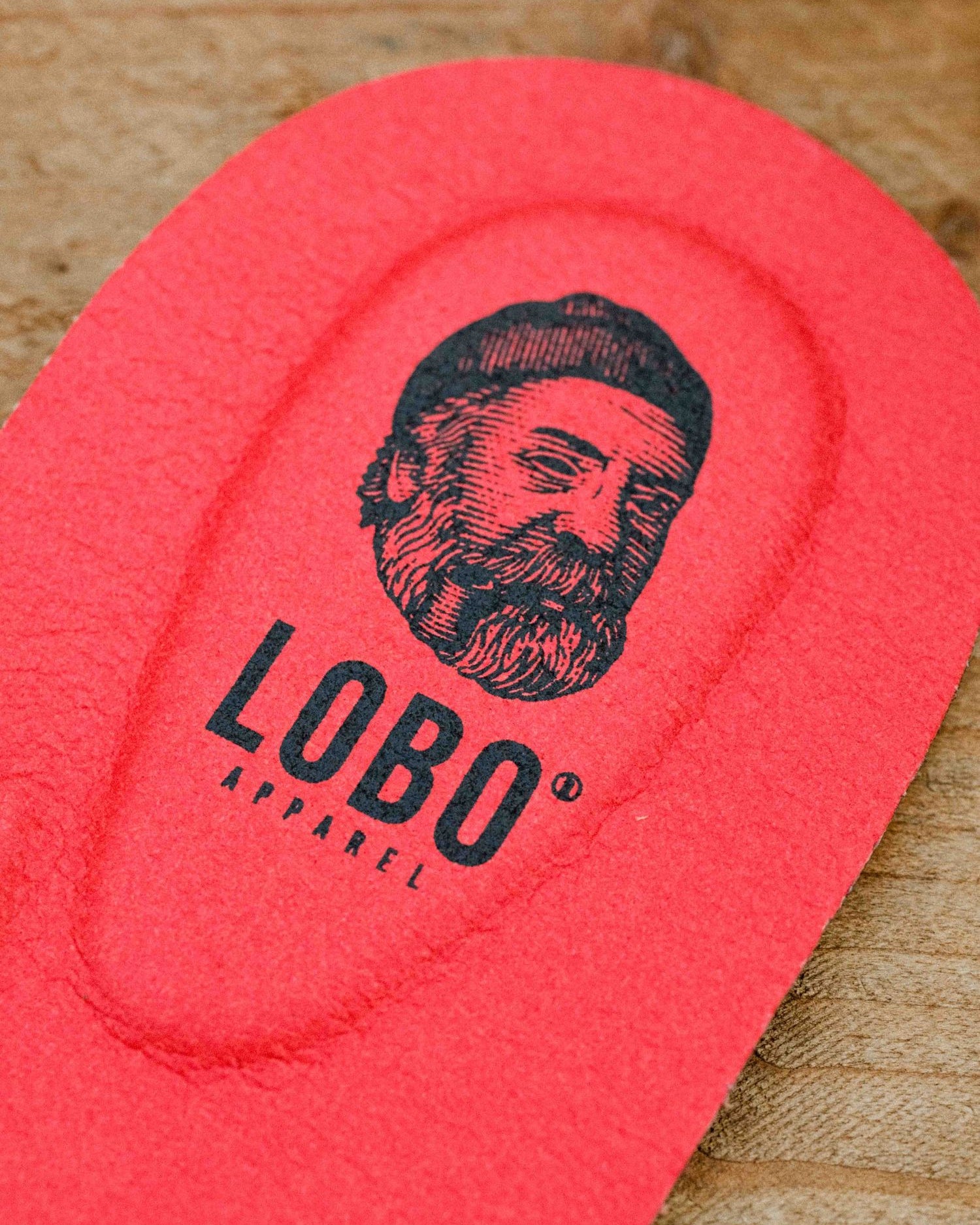 Detail of the heel area of the red Lobo Insoles leather insole, with visible black logo.