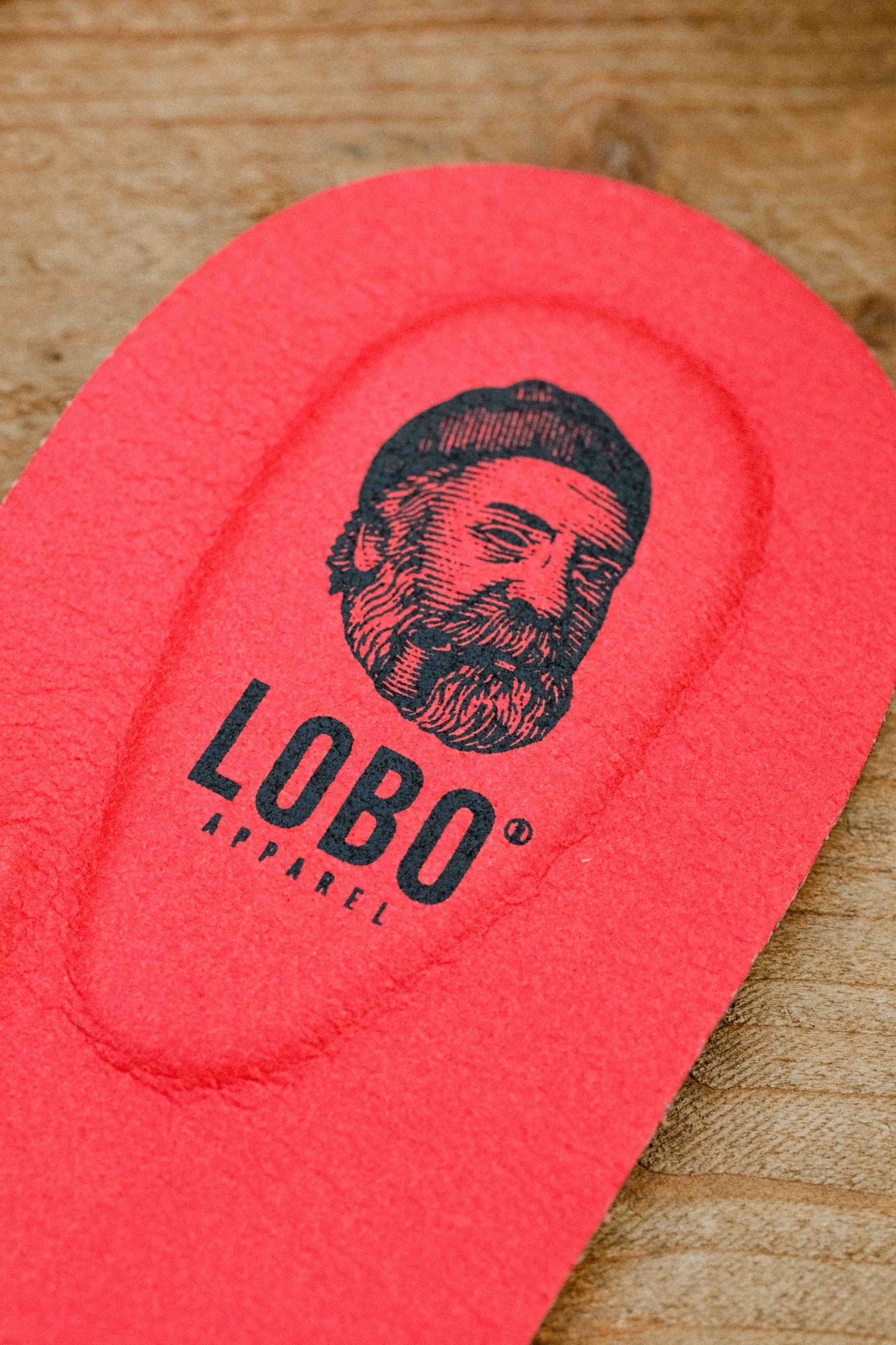 Detail of the heel area of the red Lobo Insoles leather insole, with visible black logo.