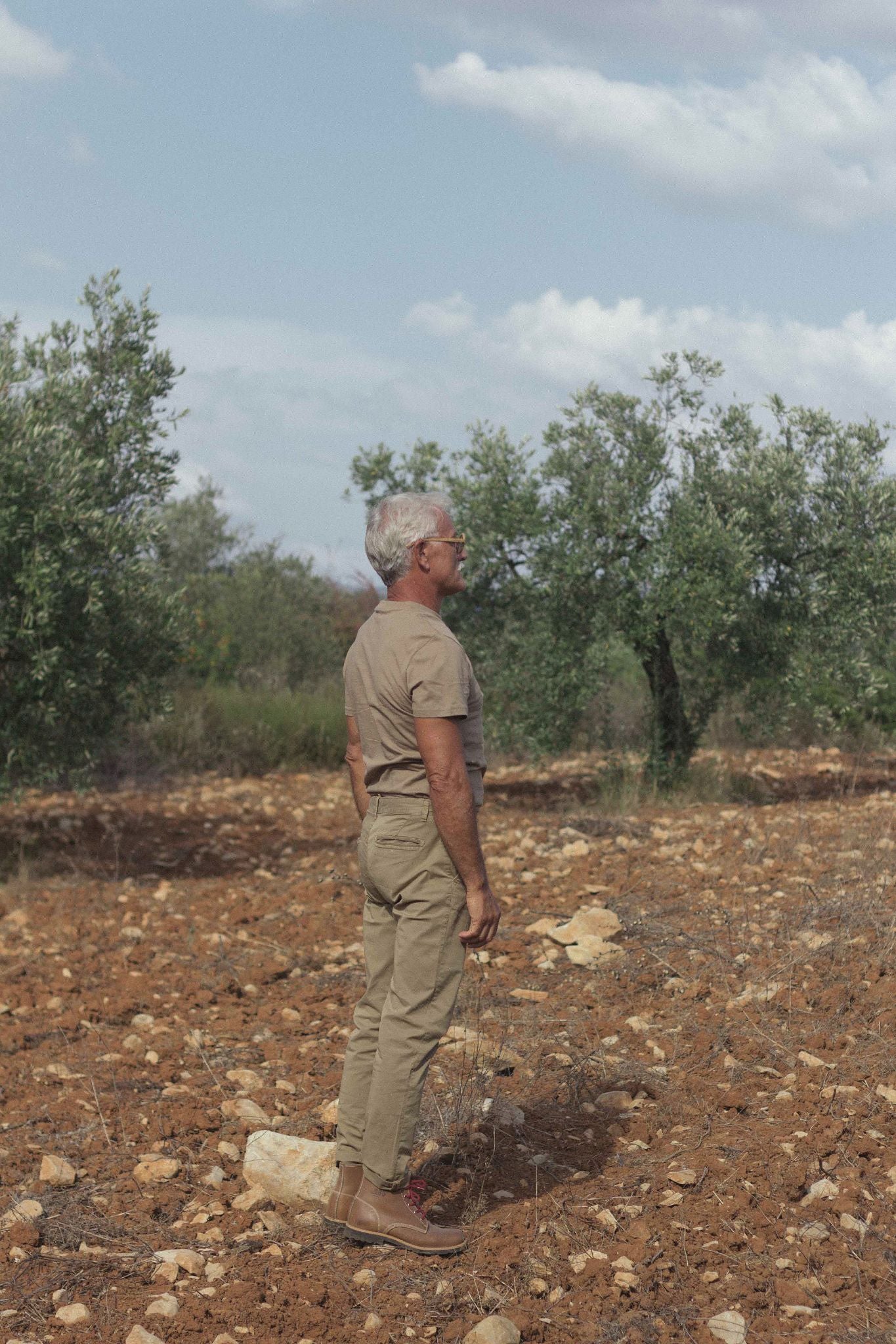 Man dressed in earth tones contemplating nature, representing the spirit of freedom and exploration of Lobo accessories.