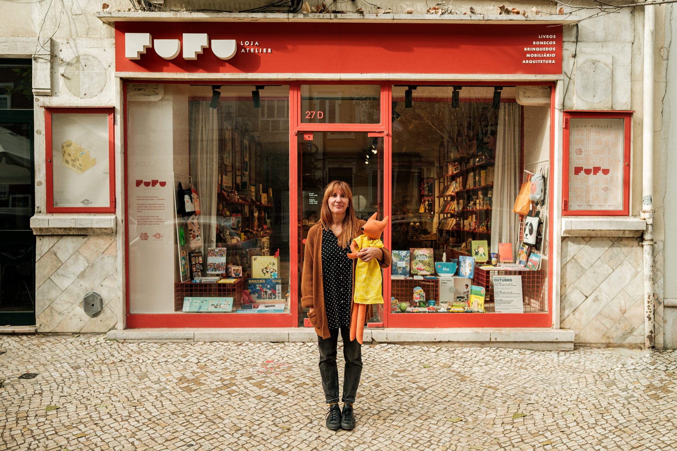 Editorial photograph of the creator of Fulana, Beltrana e Cicrana outside the Fufu storefront, highlighting the handcrafted and sustainable design partnership with Lobo Apparel.