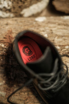 Lobo All Black Boots interior with red leather insole and branded logo, highlighting comfort and quality.