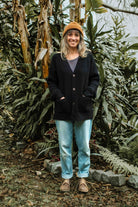 Woman wearing the black Lobo Black Wool Cardigan in a casual outdoor setting.