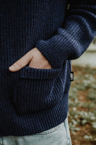Close-up of the blue ribbed knit cardigan, highlighting the front pocket and Lobo Apparel brand tab.