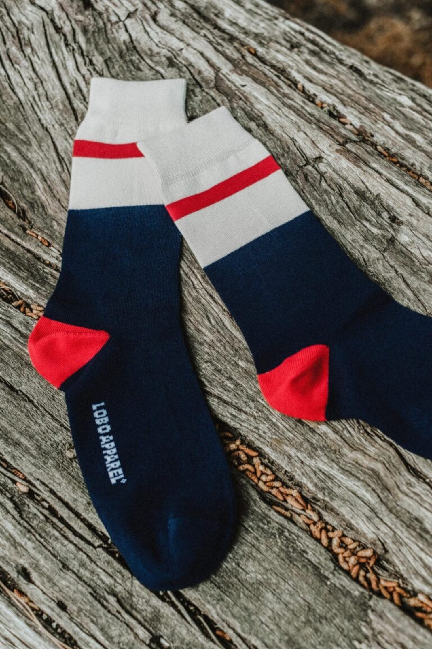 Lobo natural fiber socks with a minimalist design in blue, white, and red, highlighting the reinforced heel and toe.