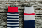 Comparison of Lobo sock patterns: one with blue and white horizontal stripes and another with a color-block design and red stripe.