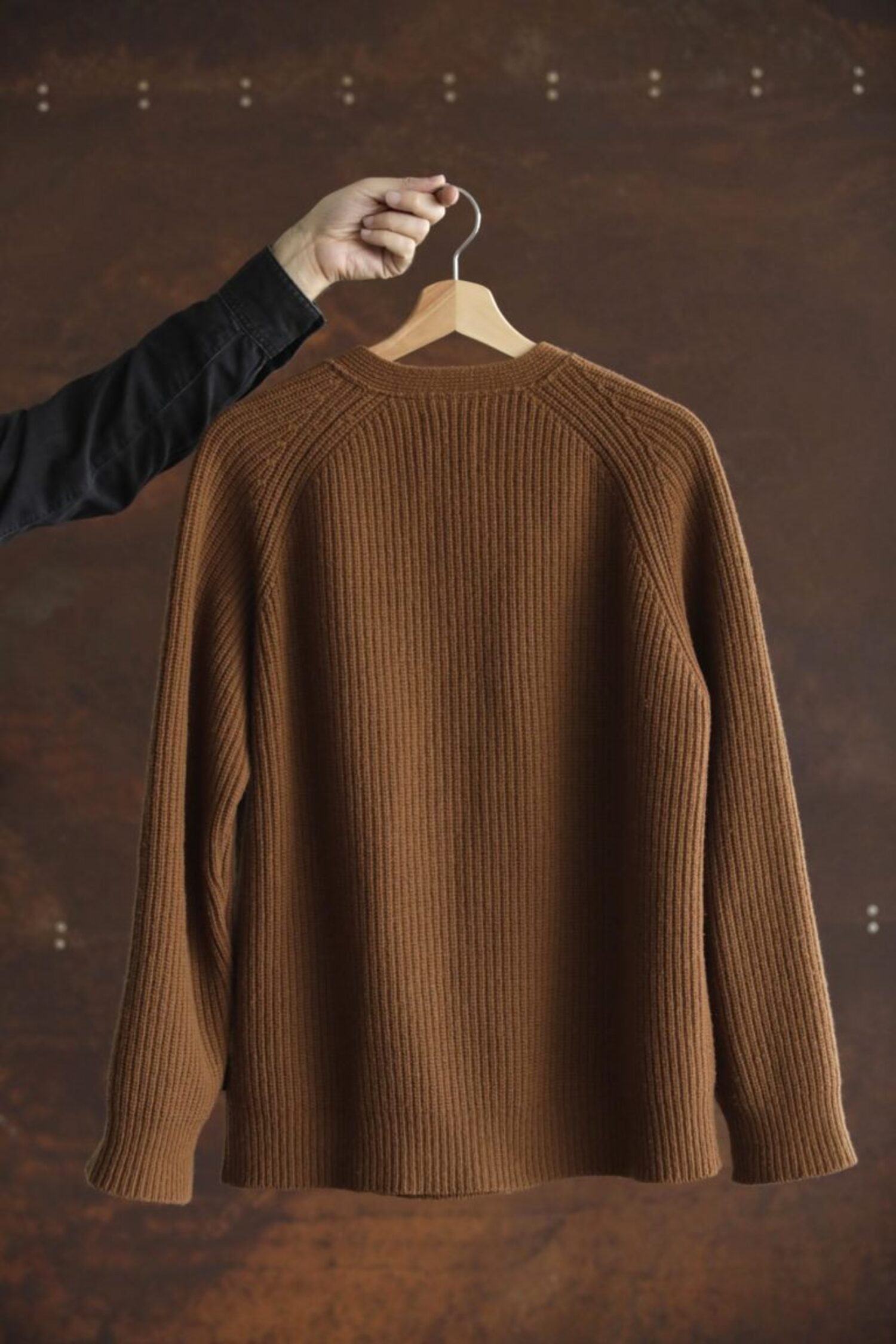 Back view of the Lobo Apparel brown wool cardigan, showing the raglan sleeves and knit structure.