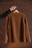 Back view of the Lobo Apparel brown wool cardigan, showing the raglan sleeves and knit structure.