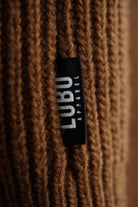 Close-up of the brown wool knit texture and Lobo Apparel black side seam brand tab.