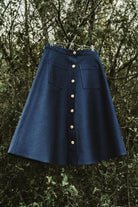 Lobo Inês dark denim skirt featuring wooden front buttons and side patch pockets, sustainable fashion.