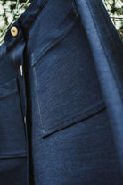 Close-up detail of premium denim texture and patch pocket stitching on the Lobo Inês skirt.