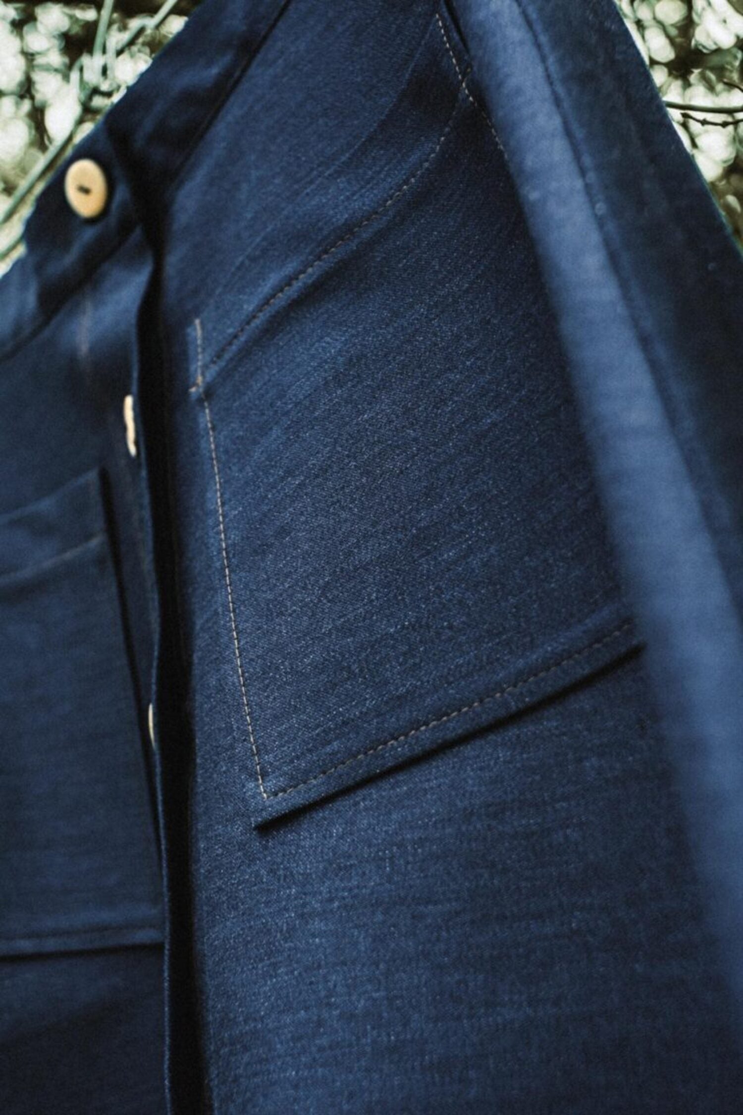 Close-up detail of premium denim texture and patch pocket stitching on the Lobo Inês skirt.