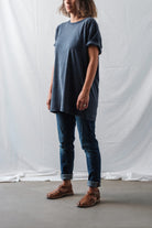 Female model in a casual oversized t-shirt and jeans outfit, wearing brown Lobo Leather Sandals, highlighting the unisex and timeless style
