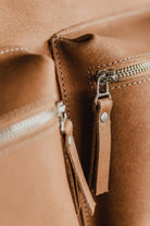 Close-up of the front zippered pockets on the Lobo Leather Suitcase, showcasing the premium leather grain and functional craftsmanship.