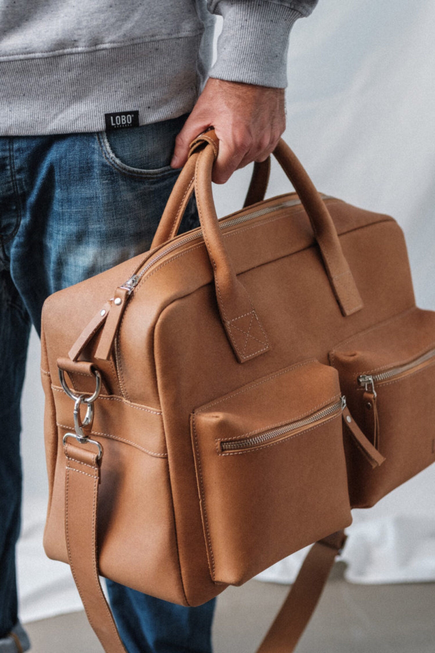 Detailed shot of the Lobo Leather Suitcase craftsmanship, showcasing the precision stitching and the rich texture of the full-grain vegetable-tanned leather.