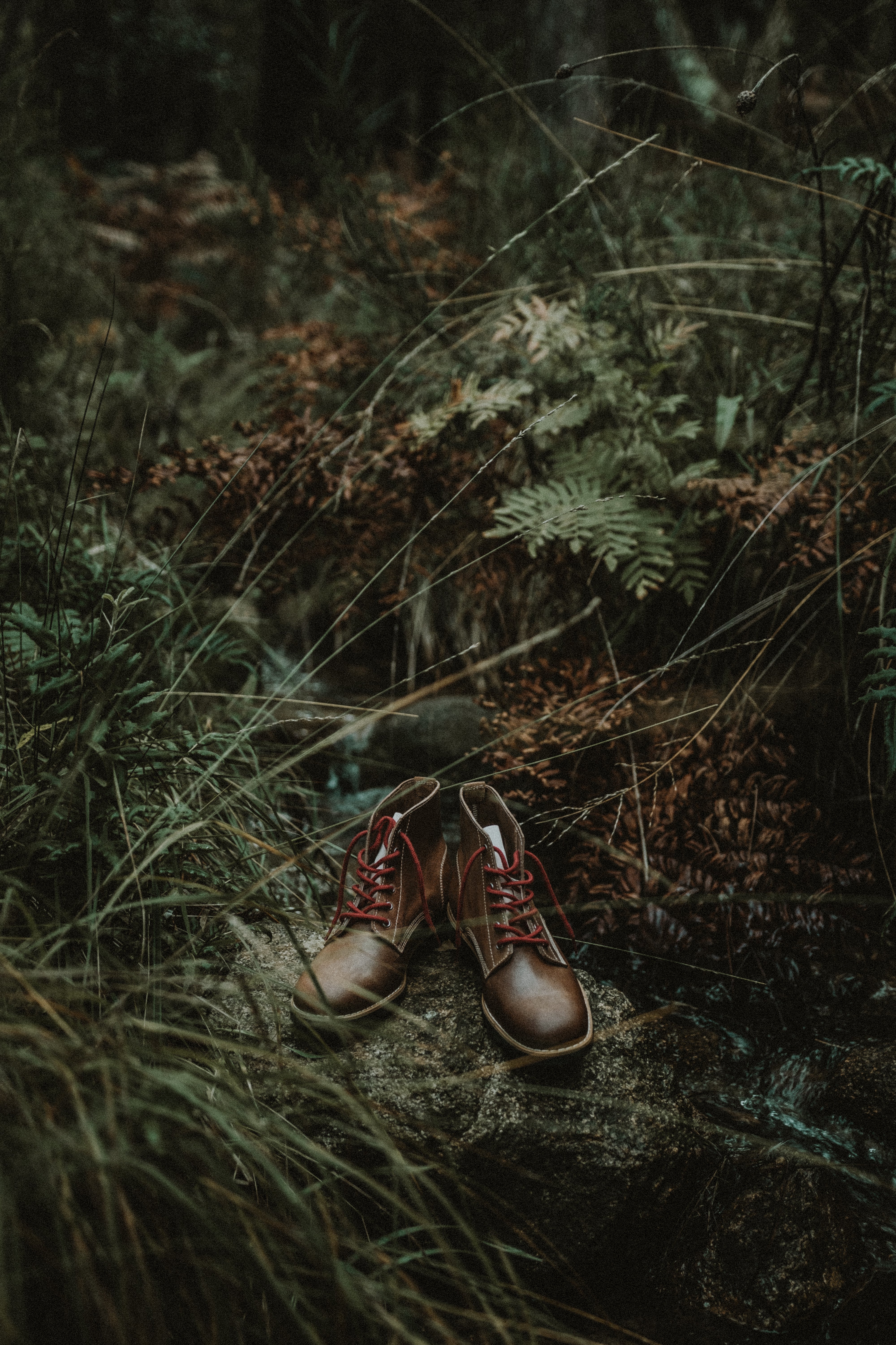 Handcrafted Lobo Raw Boots by Lobo Apparel, made in Portugal with Goodyear Welt construction, showcased in a rugged outdoor woodland setting.