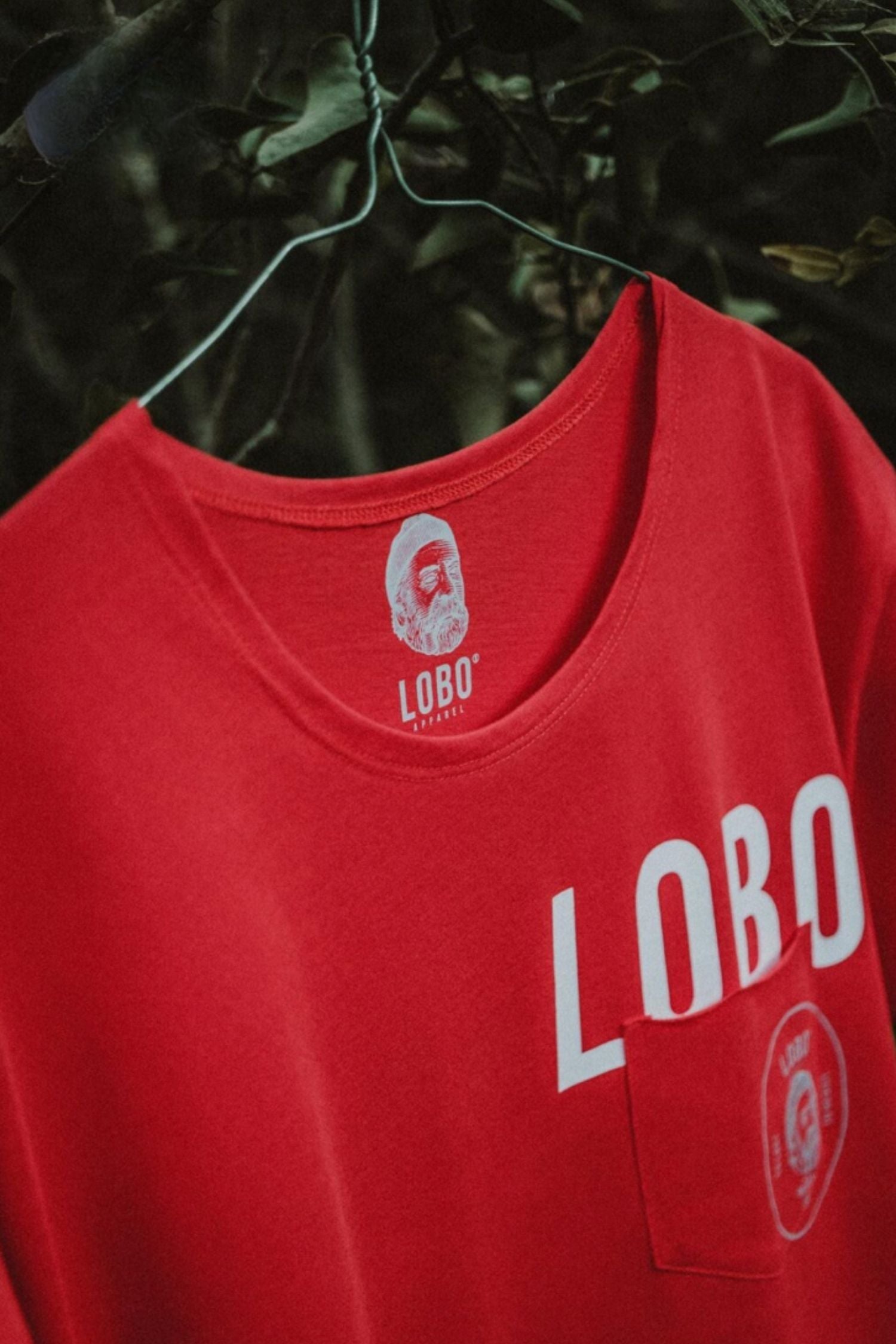 Close-up of Lobo Apparel red t-shirt neckline featuring internal screen-printed sailor logo and "LOBO" branding.