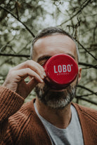 Close-up of the bottom of the red enamel mug featuring the Lobo Apparel logo in white.