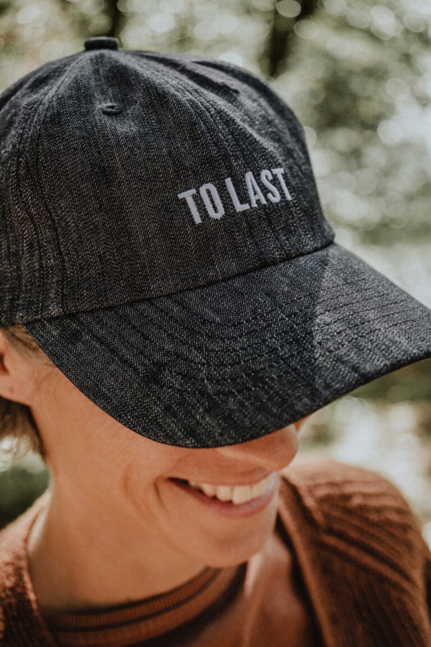 Close-up of the grey Lobo cap highlighting the front embroidery detail with the phrase "To Last".