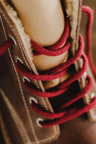 Close-up detail of the red laces and metallic eyelets on the Lobo leather boots.