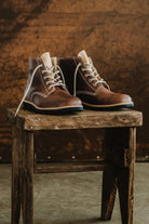 Lobo Warm Boots in premium leather with cream lace option on a rustic stand.