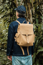 Back view of a male model wearing the Lobo x Naked Malt backpack, highlighting leather straps and structured everyday design.