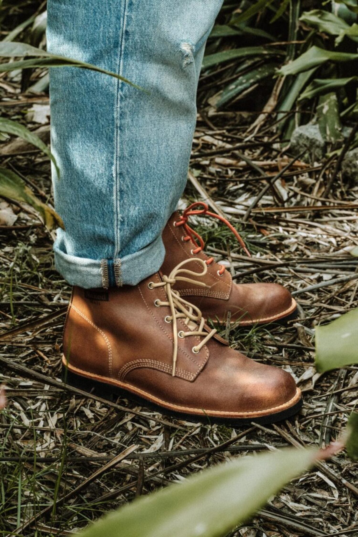 Side profile of Lobo x Naked Malt leather boots featuring a durable rubber sole and cream laces.