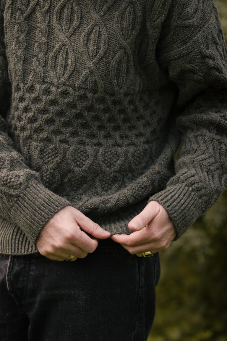 Close-up of the texture of the "Verde Grisalho" Lobo x Do Zero sweater, showing the different embossed knit patterns and the ribbed cuff, made from 100% recycled yarn.