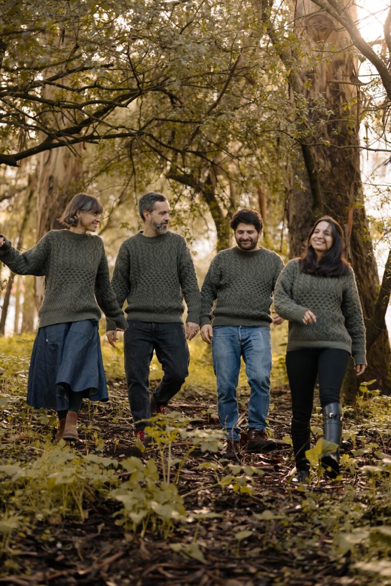A group of four people walking through a forest, wearing the unisex Verde Grisalho sweater from the Lobo x Do Zero collaboration, made from 100% recycled yarn.