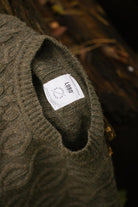 Close-up of a forest green knit sweater collar, showing the exclusive LOBO Apparel x Do Zero collaboration label.