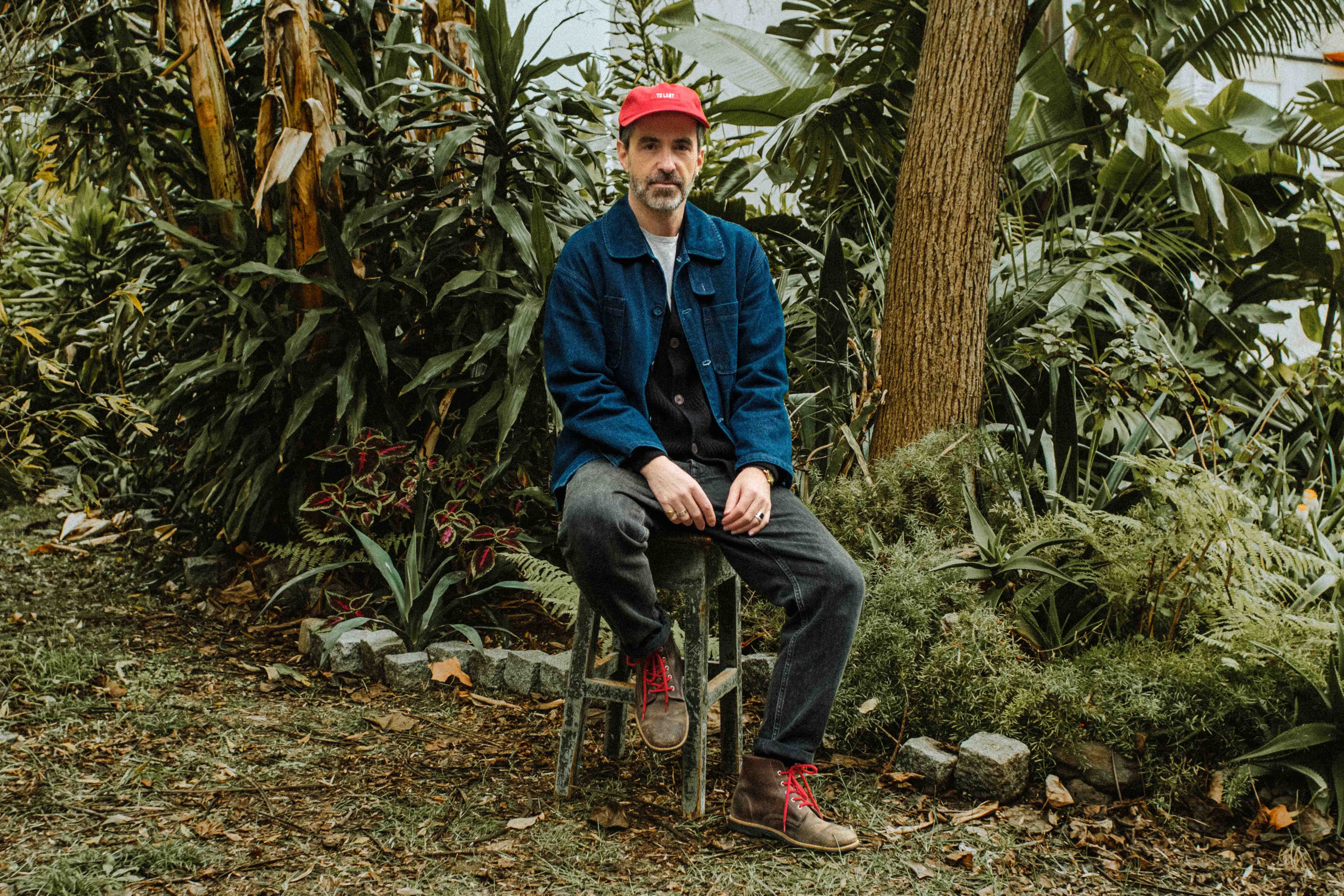 Portrait of Lobo Apparel founder Bruno Pereira wearing a blue jacket and the iconic Lobo Raw Boots in raw leather with red laces.