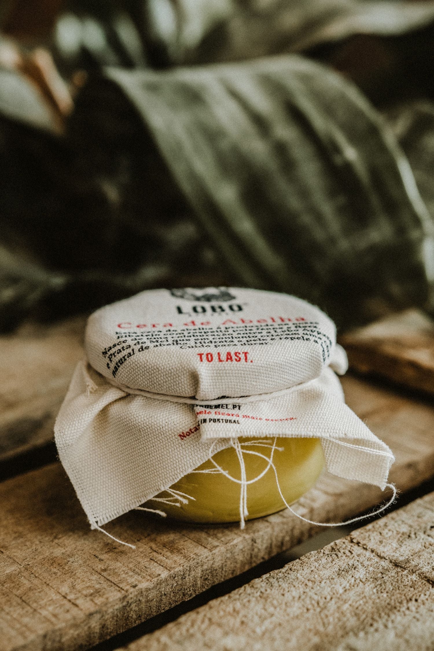 Beeswax boot conditioner jar with "To Last" label, emphasizing durability and leather footwear care.