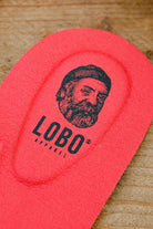 Detail of the heel area of the red Lobo Insoles leather insole, with visible black logo.