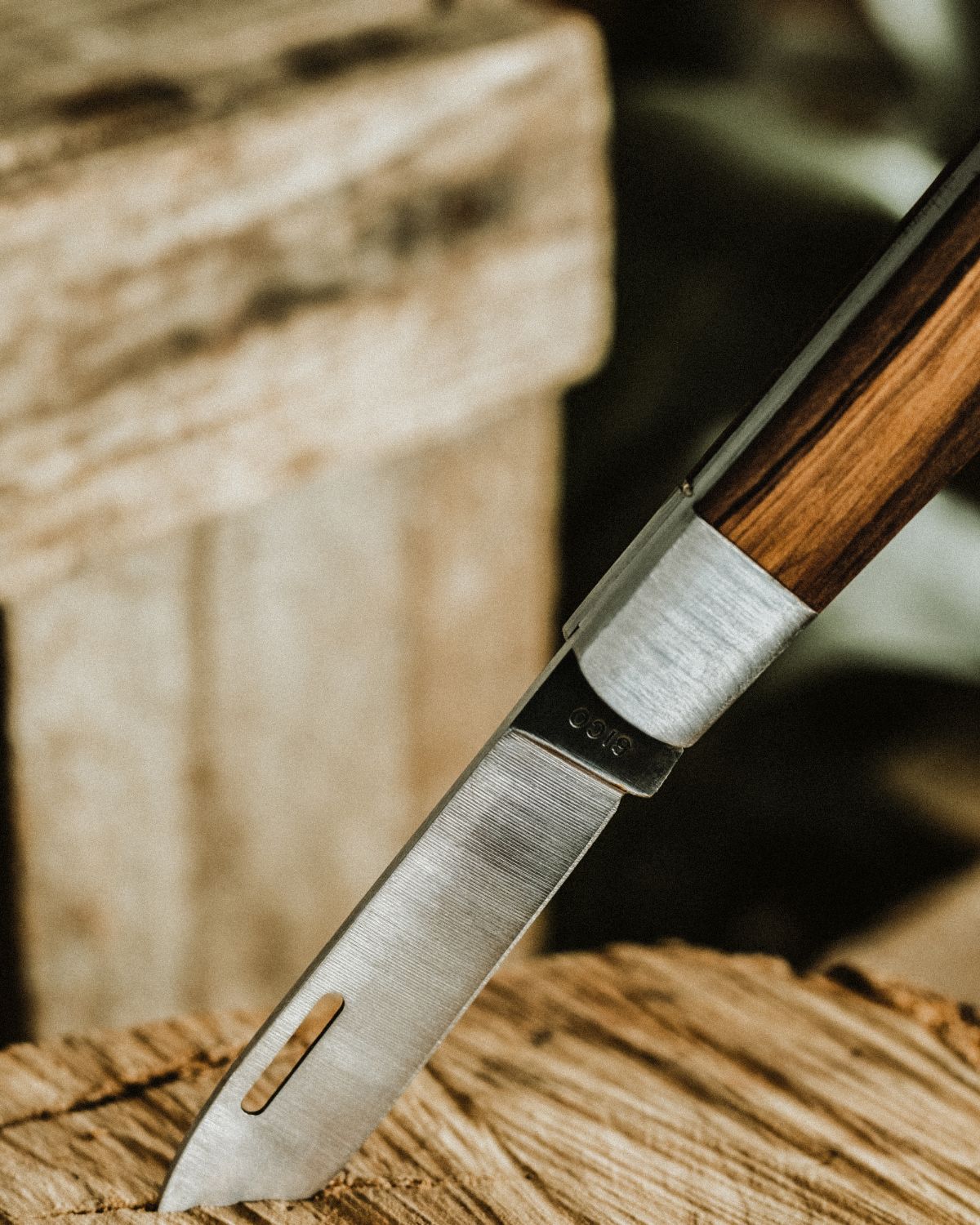 Detail of the steel blade and metal bolster of a LOBO artisanal knife, highlighting the precise fit with the olive wood handle. Precision cutlery work by Fernando Mendes.